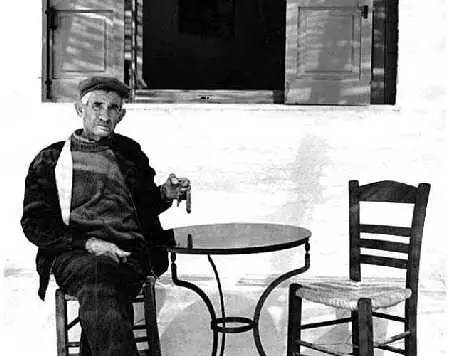 懒洋洋地坐在传统希腊咖啡屋小椅子上的老一代希腊人